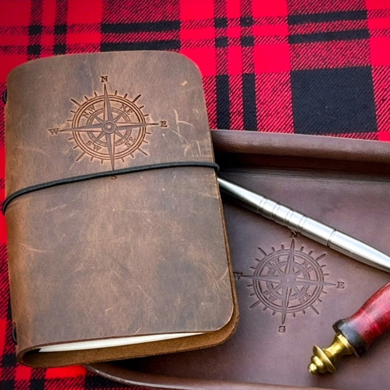 Leather journal with a compass design engraved on the cover