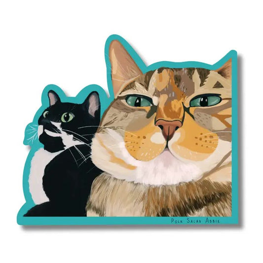Sticker depicting two closeup cat faces over a teal background