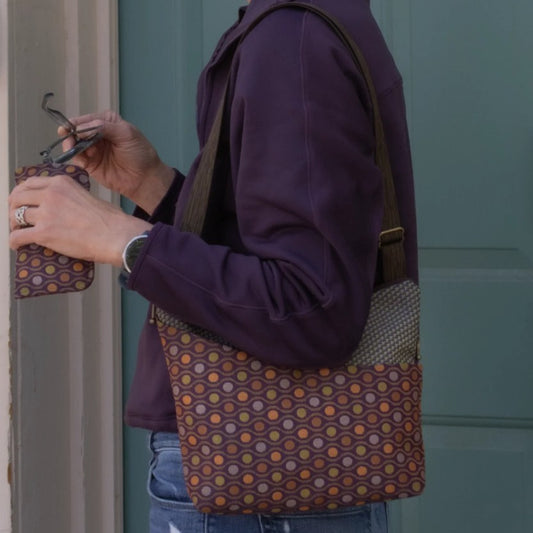 Person with matching purse and eyeglass case in purple geometric patterns
