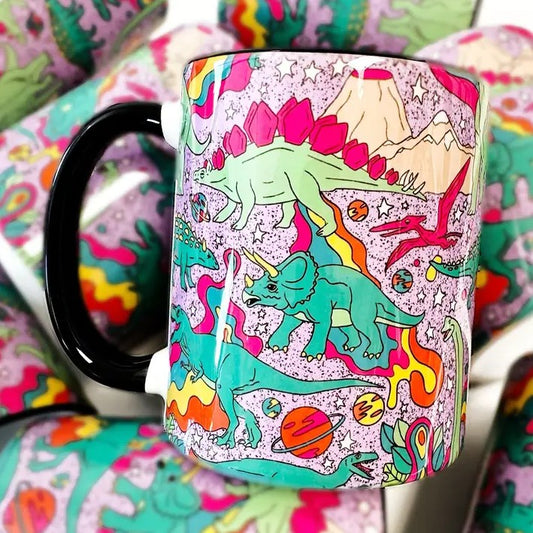 Purple mug with colorful dinosaurs, planets and volcanoes on it