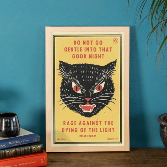 Art print depicting an angry black cat face on a bright yellow background and red text that reads "Do not go gentle into that good night. Rage against the dying of the light"