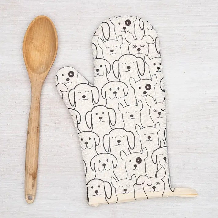 White oven mitt with a pattern of smiling dogs