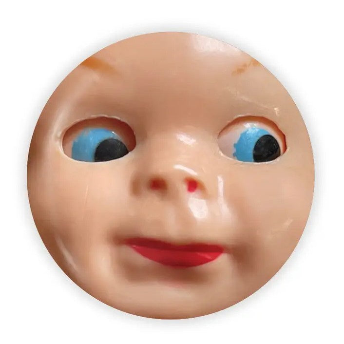 Magnet featuring a close-up image of a doll face