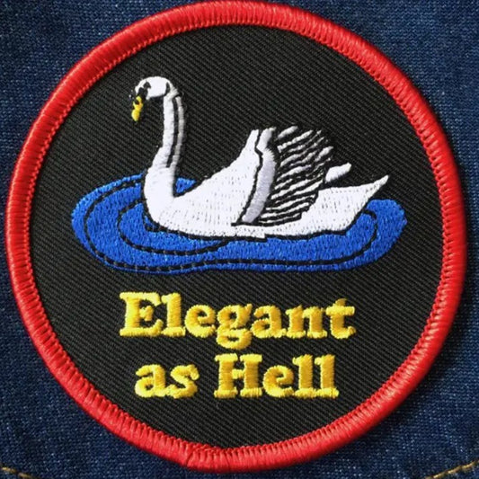 Iron-on fabric patch depicting a swan above the words "Elegant as Hell" on a black background