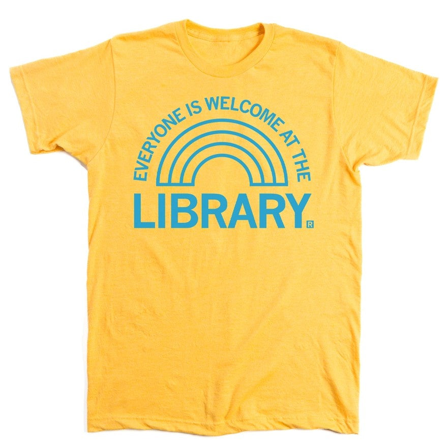 Yellow t-shirt with a light blue rainbow shaped graphic and text that reads "Everyone is welcome at the library"