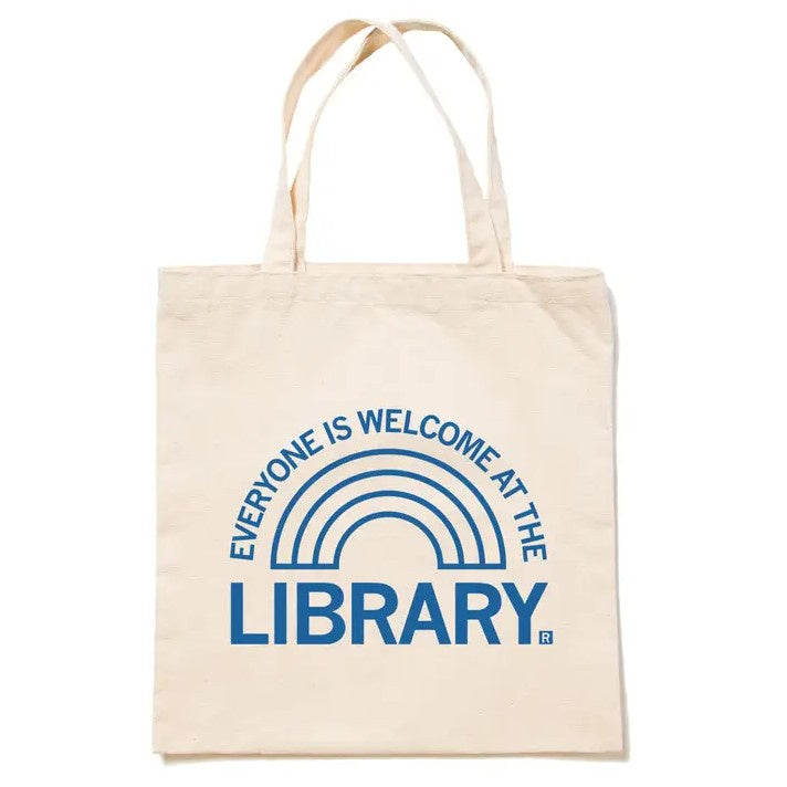 White tote bag with a simple blue rainbow graphic and text "Everyone is welcome at the library"