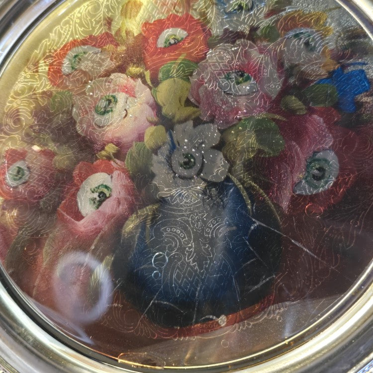 Closeup of embossed floral detailing on the surface of the metal tray.