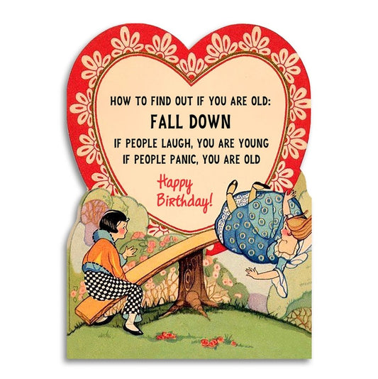 Birthday card featuring an illustration of one woman falling off a see-saw and another woman watching