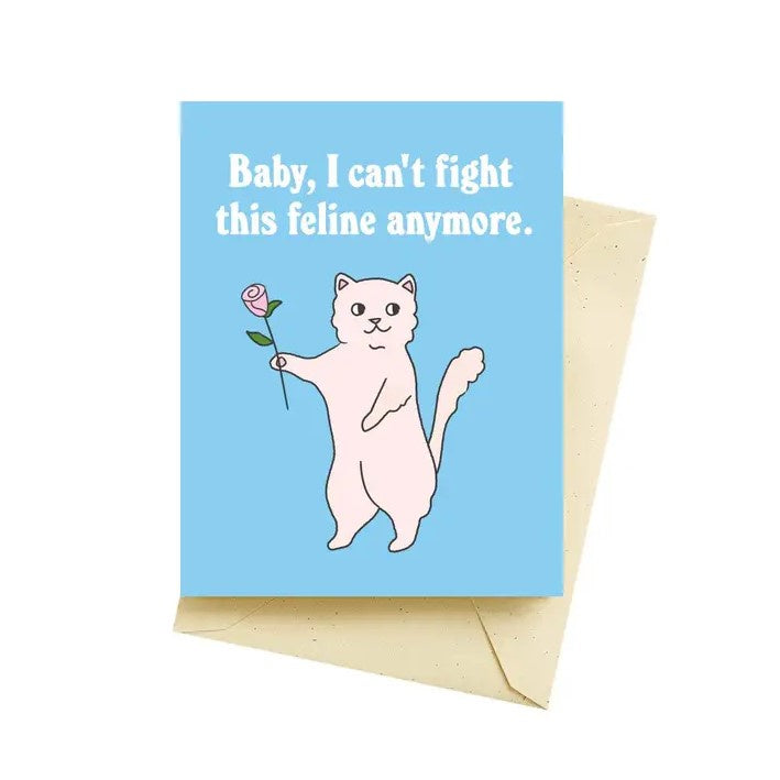 a blue valentines card featuring a smiling pink cat holding a rose and the words "baby, I can't fight this feline anymore."