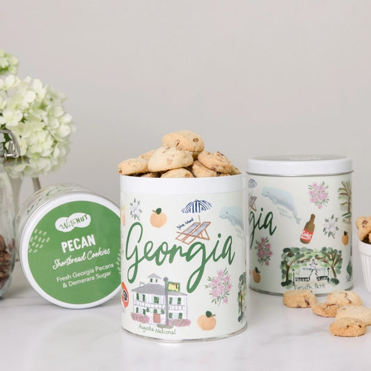 Mint green decorative cookie tins with "Georgia" on the front and watercolor illustrations of various Georgia landmarks around the label