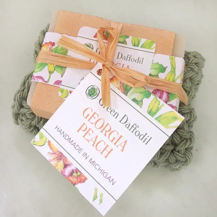 Peach scented bar soap packaged with a green scrub cloth