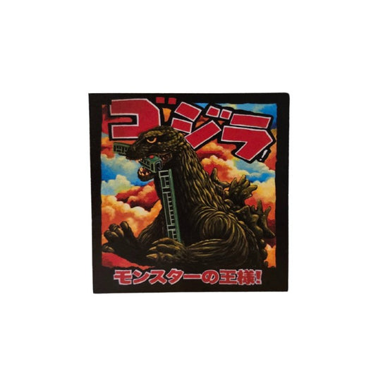 Magnet depicting Godzilla with half of a train in his mouth