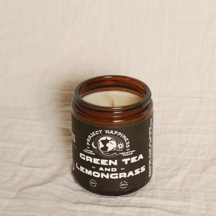 Candle in a black jar labeled "Green Tea and Lemongrass"