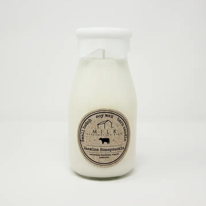 A soy wax candle designed to look like an old fashioned milk bottle in the scent "jasmine honeysuckle."