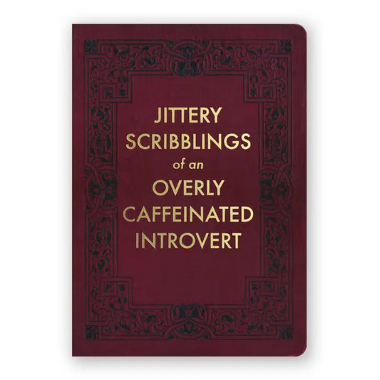 Burgundy journal with black ornate detailing and gold lettering that reads "Jittery scribblings of an overly caffeinated introvert"