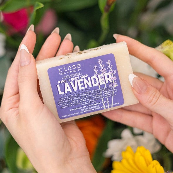 Person holding a bar of lavender scented soap with purple packaging