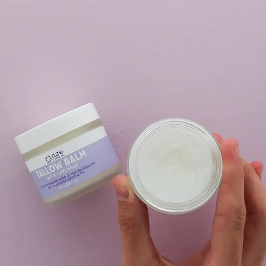 Open jar of tallow balm on a lavender background