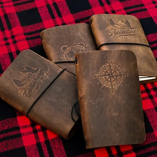 Collection of brown leather journals with different designs on the covers