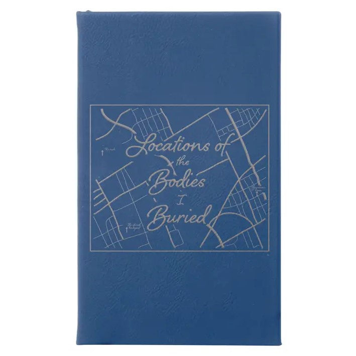 Blue leather journal with an abstract map and silver lettering that reads "Locations of the Bodies I Buried"