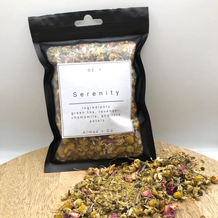Packaged tea blend labeled 'Serenity' with loose tea on a wooden board.