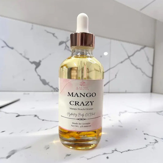 A bottle of mango, peach and orange scented body oil with a dropper