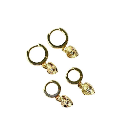 Gold huggie earrings with charms shaped like etched hearts