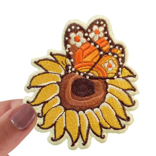Iron-on fabric patch depicting a monarch butterfly on a sunflower
