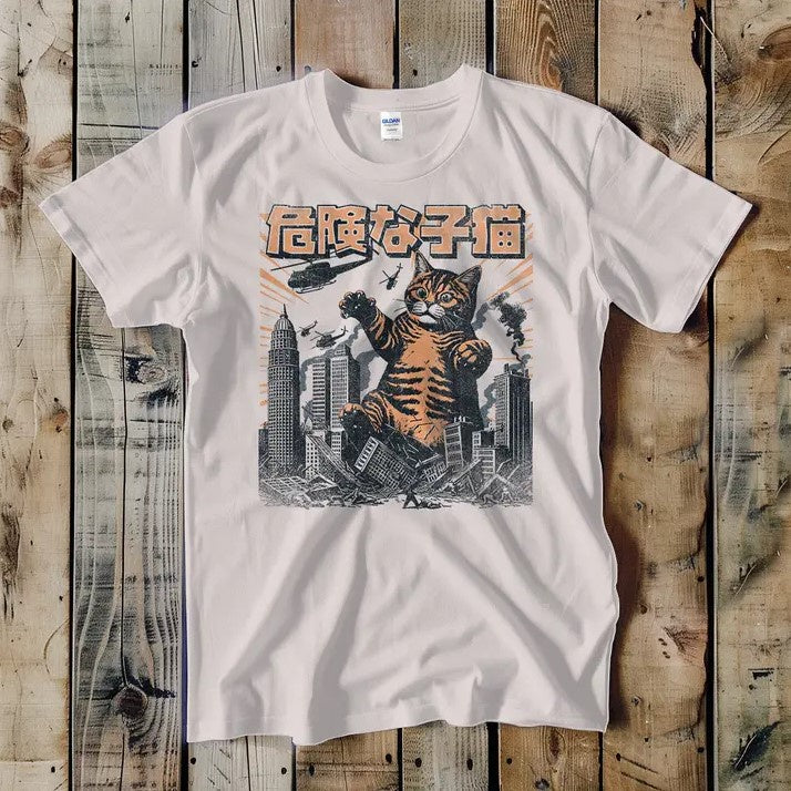 A white tee shirt featuring an illustration of a giant cat destroying a city in the style of Godzilla.