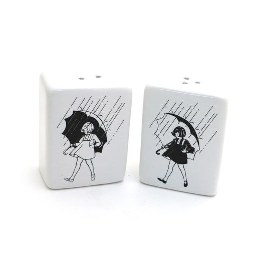 Ceramic salt and pepper shakers featuring an image of a girl with an umbrella in the rain