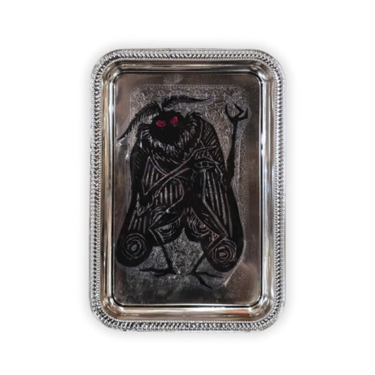 Silver metal tray with an image of red-eyed Mothman on it
