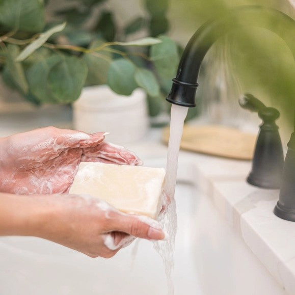 Person washing their hands with a bar of soap
