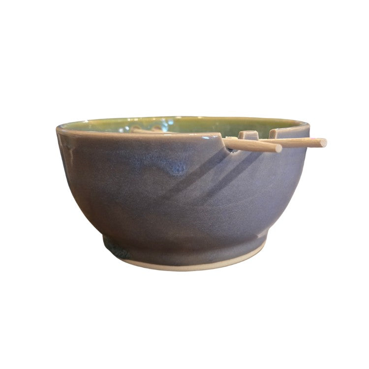Lavender ceramic bowl holding wooden chopsticks