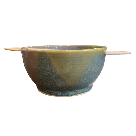 Green and blue ceramic bowl holding wooden chopsticks
