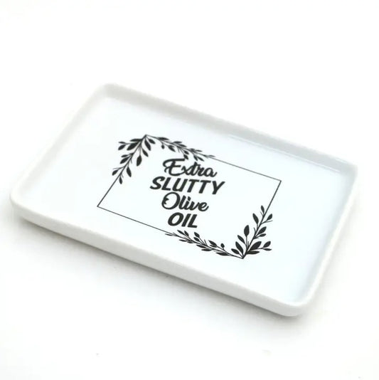 White ceramic tray with leaf design and text "Extra slutty olive oil"