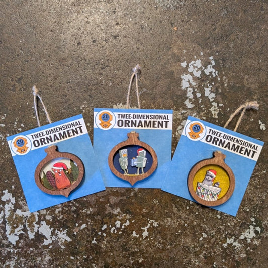 Three wooden Christmas ornaments. The first is a beaver in a Santa hat, the second is a robot in a Santa hat giving a gift to another robot, and the third is a raccoon in a Santa hat peeking out of a trash can