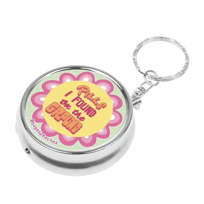 Keychain that reads "Pills I found on the Ground" in pink and yellow funky font