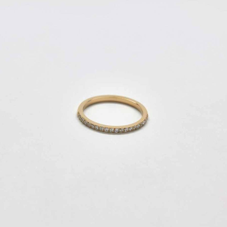 A thin gold ring studded with small white crystals.