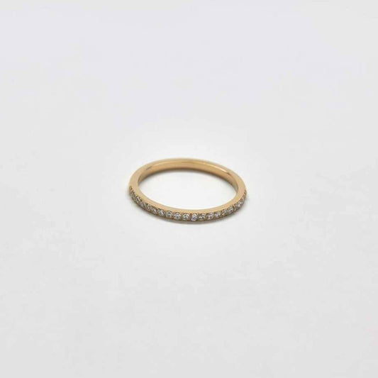 A thin gold ring studded with small white crystals.