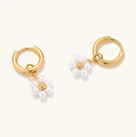Gold huggie earrings with dangling daisy charms