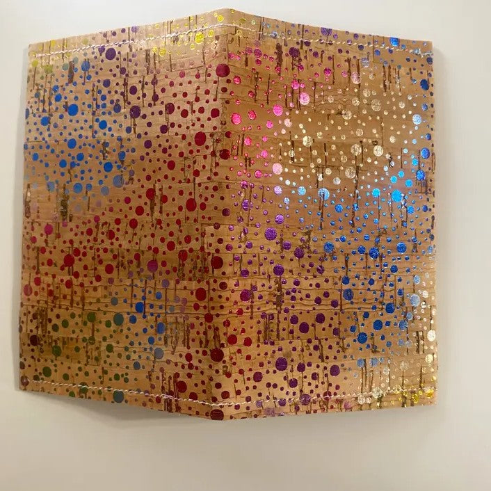 A rectangular light brown cork wallet with iridescent rainbow speckles