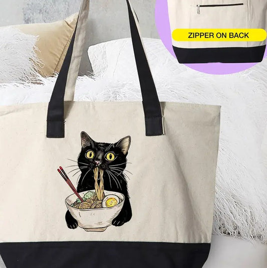 A canvas tote with black bottom and handles. There is an image of a black cat eating a bowl of ramen on the side