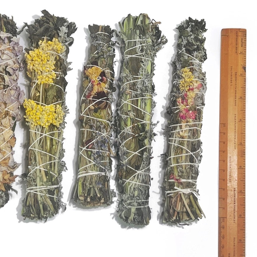 A variety of smudge sticks with different kinds of dried flowers all measuring around eight inches long.