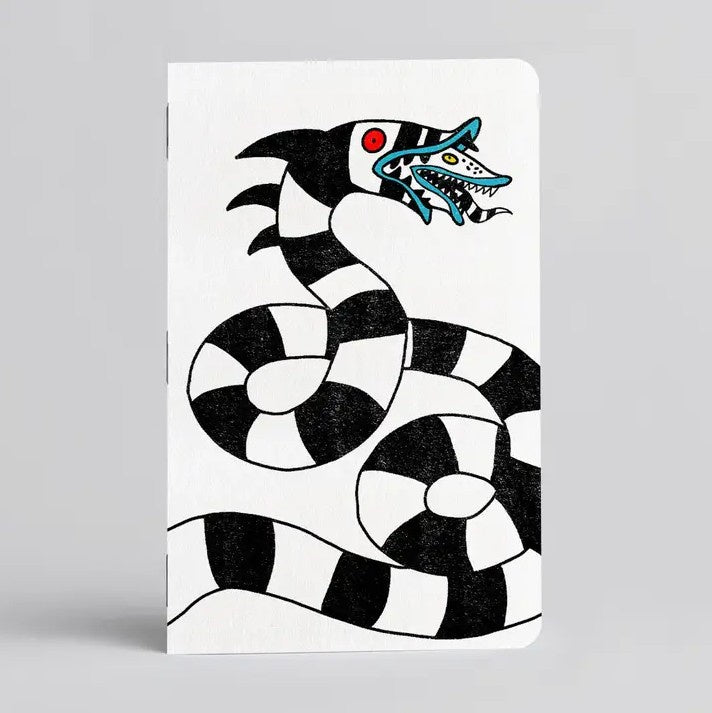 White notebook with a black and white striped Sandworm illustration on the cover