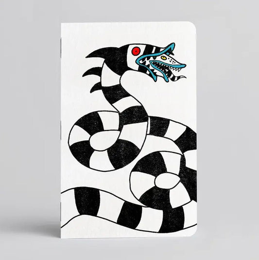 White notebook with a black and white striped Sandworm illustration on the cover