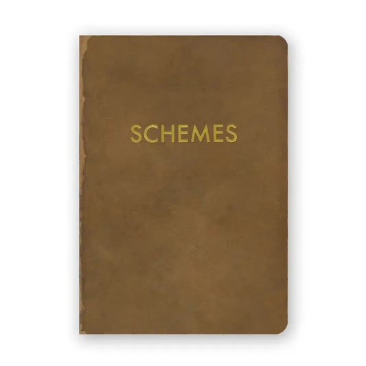 A small light brown journal with the word "Schemes" embossed in gold print on the front.