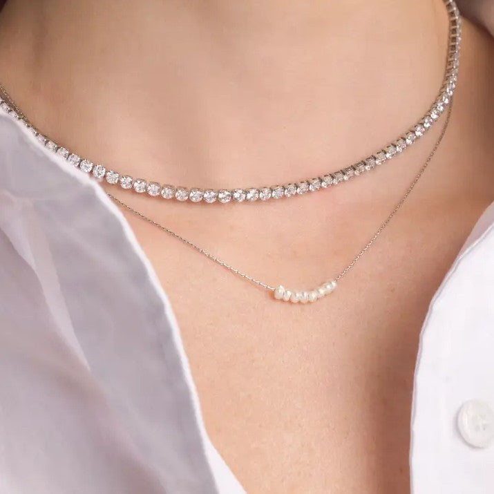 Person wearing a silver necklace with crystals