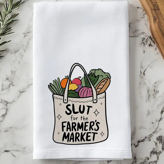 Tea towel with an image of a tote bag filled with vegetables and text that reads "Slut for the farmer's market"