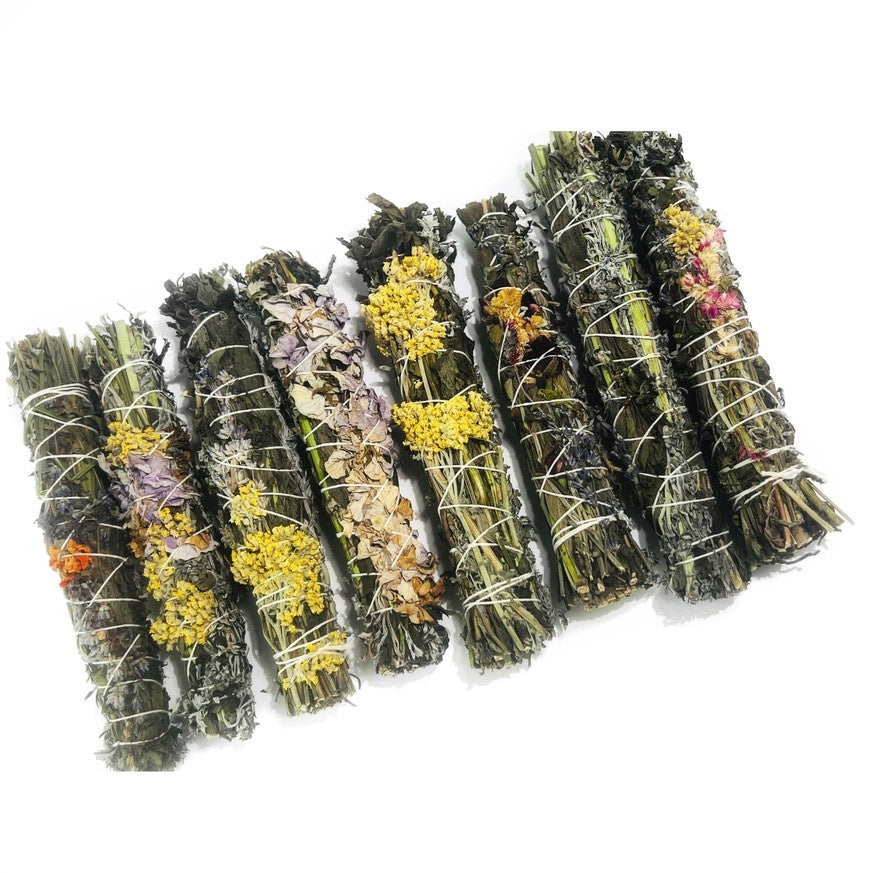 A variety of smudge sticks with different kinds of dried flowers.