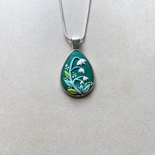 polymer clay snowdrop flower on a teardrop pendant