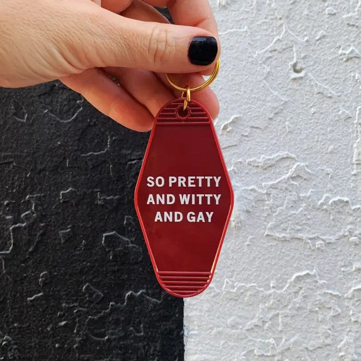 Red keychain with white text reading "So pretty and witty and gay"
